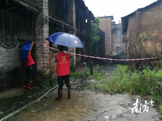 黨群志愿者冒雨拉起警戒線。