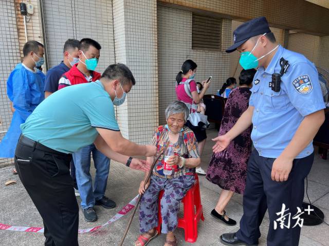 連州市委常委、副市長、九陂鎮(zhèn)黨委書記綦鴻偉在核酸檢測現(xiàn)場協(xié)助老人參加核酸檢測，為老人做好防暑措施。